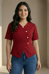 Woman wearing a red blouse with white buttons and blue jeans against a beige background