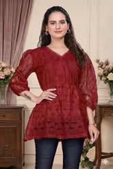 Woman wearing a red lace dress in an elegant indoor setting