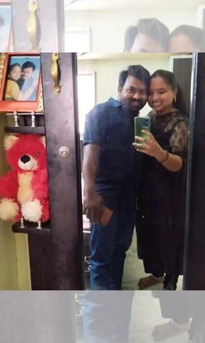 Two people taking a selfie in front of a mirror with a teddy bear and photo frame in the background.