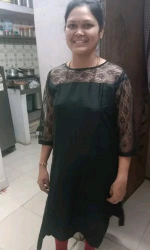 Woman wearing a black dress with lace details in a kitchen setting
