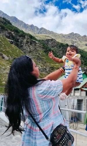 Woman holding a baby with mountains in the background