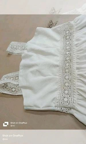 White top with lace details on a neutral background