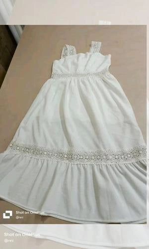 White dress with embellishments on a beige surface