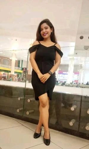 Woman in a black dress standing in a mall setting