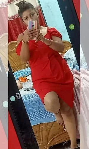 Person wearing a red dress sitting on a chair with a blurred background