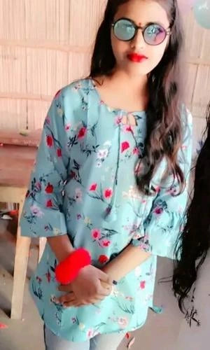 Woman wearing a light blue floral top with a blurred background