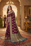 Woman in a traditional purple saree with gold patterns in an elegant interior setting.