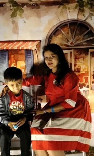 Woman and child sitting together in a decorated room with a wagon wheel in the background