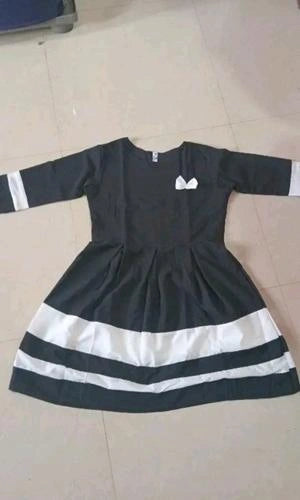 Black dress with white accents on a tiled floor