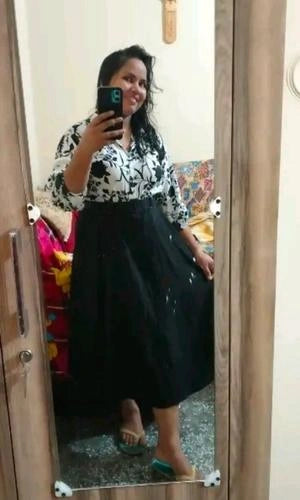 Person taking a mirror selfie wearing a black and white outfit.