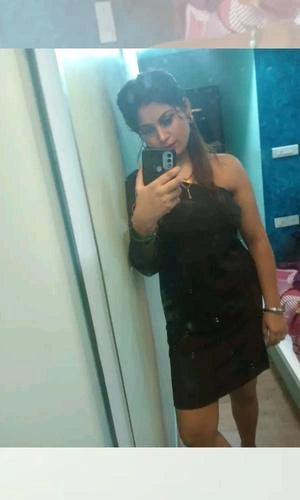 Person taking a mirror selfie wearing a black dress.