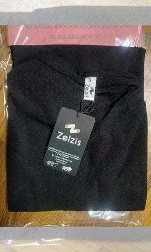 Black garment with a Zelzis tag on a wooden surface