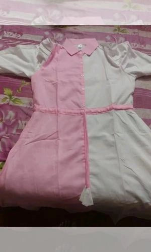 Partial view of a pink and gray dress on a floral bedspread
