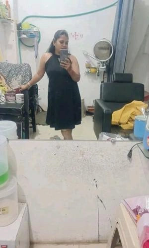 Person taking a mirror selfie in a salon setting