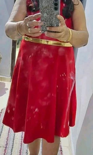 Person wearing a red dress with gold belt taking a mirror selfie.
