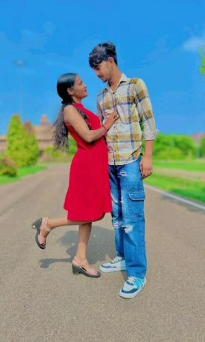 Two people standing on a road with a scenic background