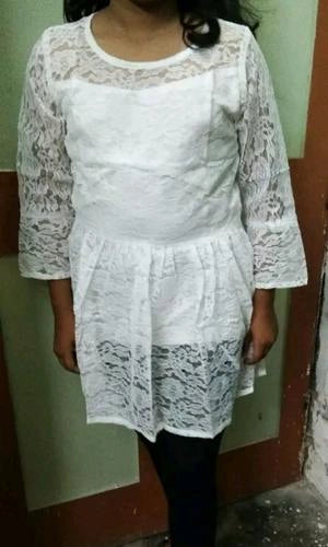 White lace dress worn by a person against a plain background