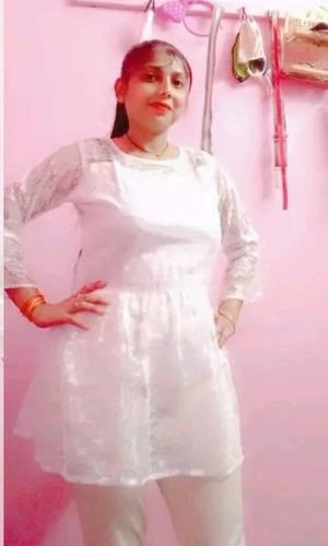 Person wearing a white dress against a pink background