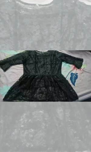 Black dress on a gray surface with a floral patterned towel underneath