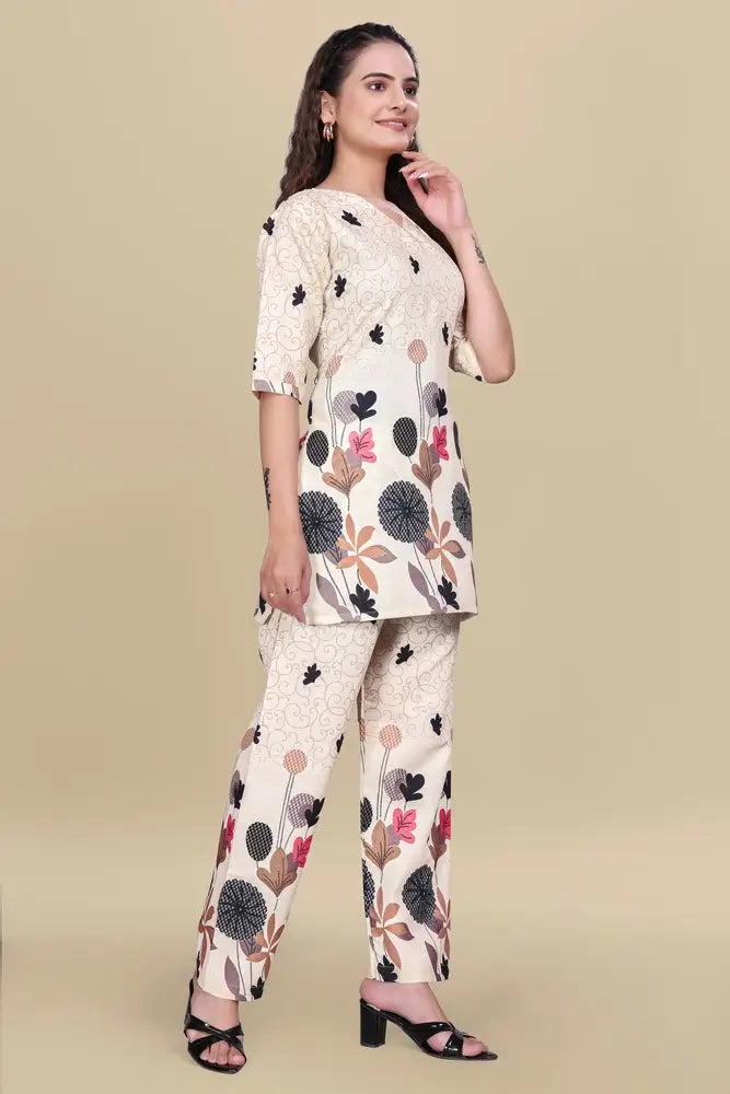 Woman wearing a floral kurta with matching pants on a beige background