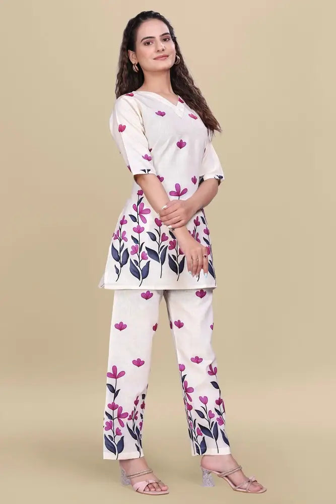 Woman wearing a white outfit with pink floral patterns on a beige background