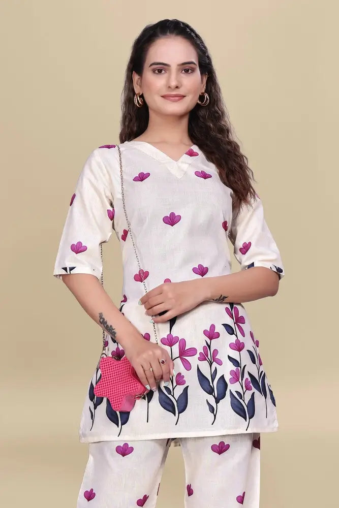 Woman wearing a white kurta with pink floral patterns on a beige background