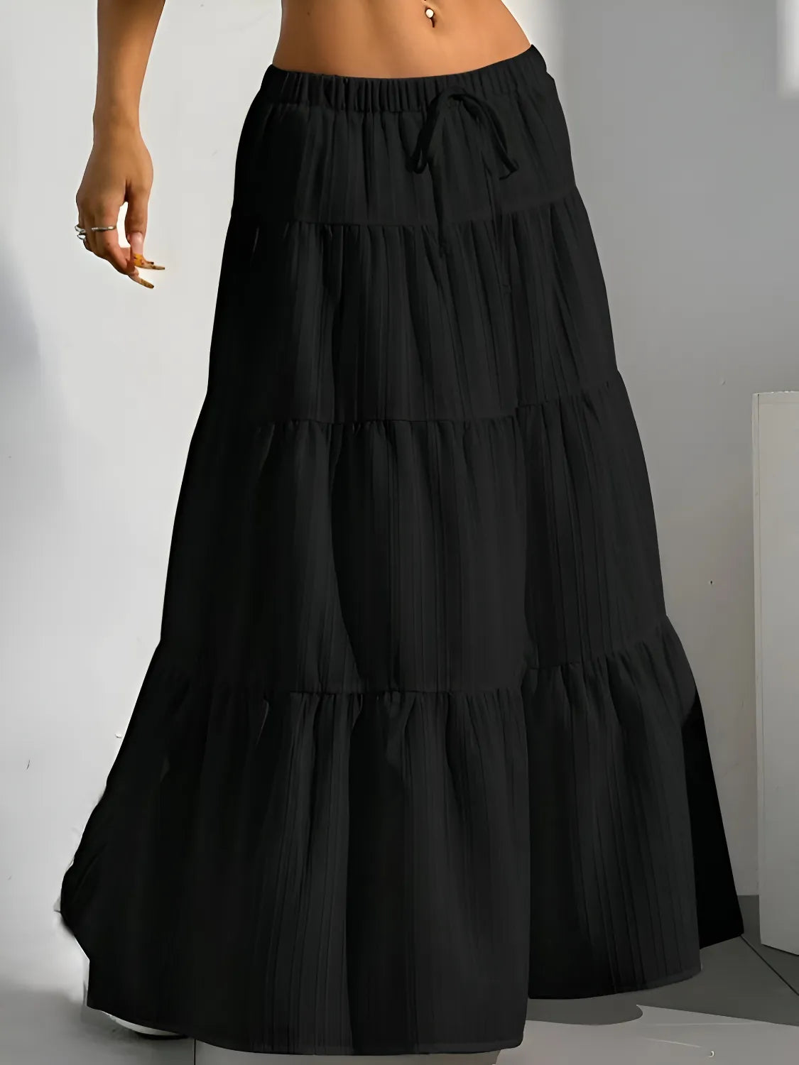 Black tiered maxi skirt on a plain background