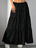 Black tiered skirt worn by a person on a gray background
