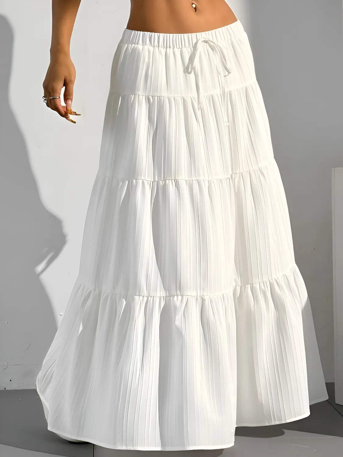 White tiered skirt worn by a person on a plain background