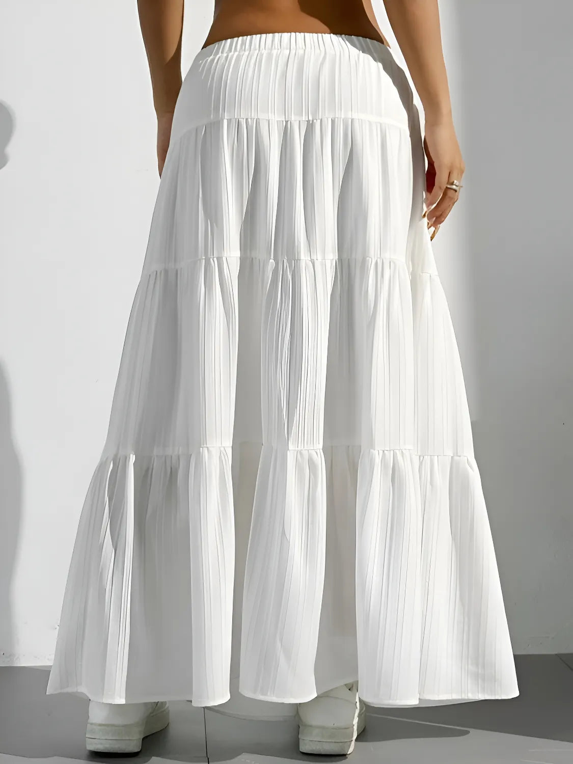 White tiered skirt worn by a person on a plain background
