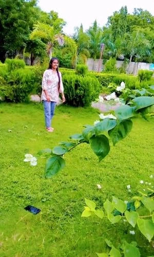 Woman standing in a garden with greenery and flowers