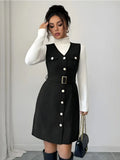 Woman wearing a black dress with white buttons against a plain background