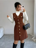 Woman taking a mirror selfie wearing a brown dress with white buttons, white turtleneck, and black knee-high boots.