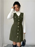 Woman wearing a green dress with white buttons against a plain background
